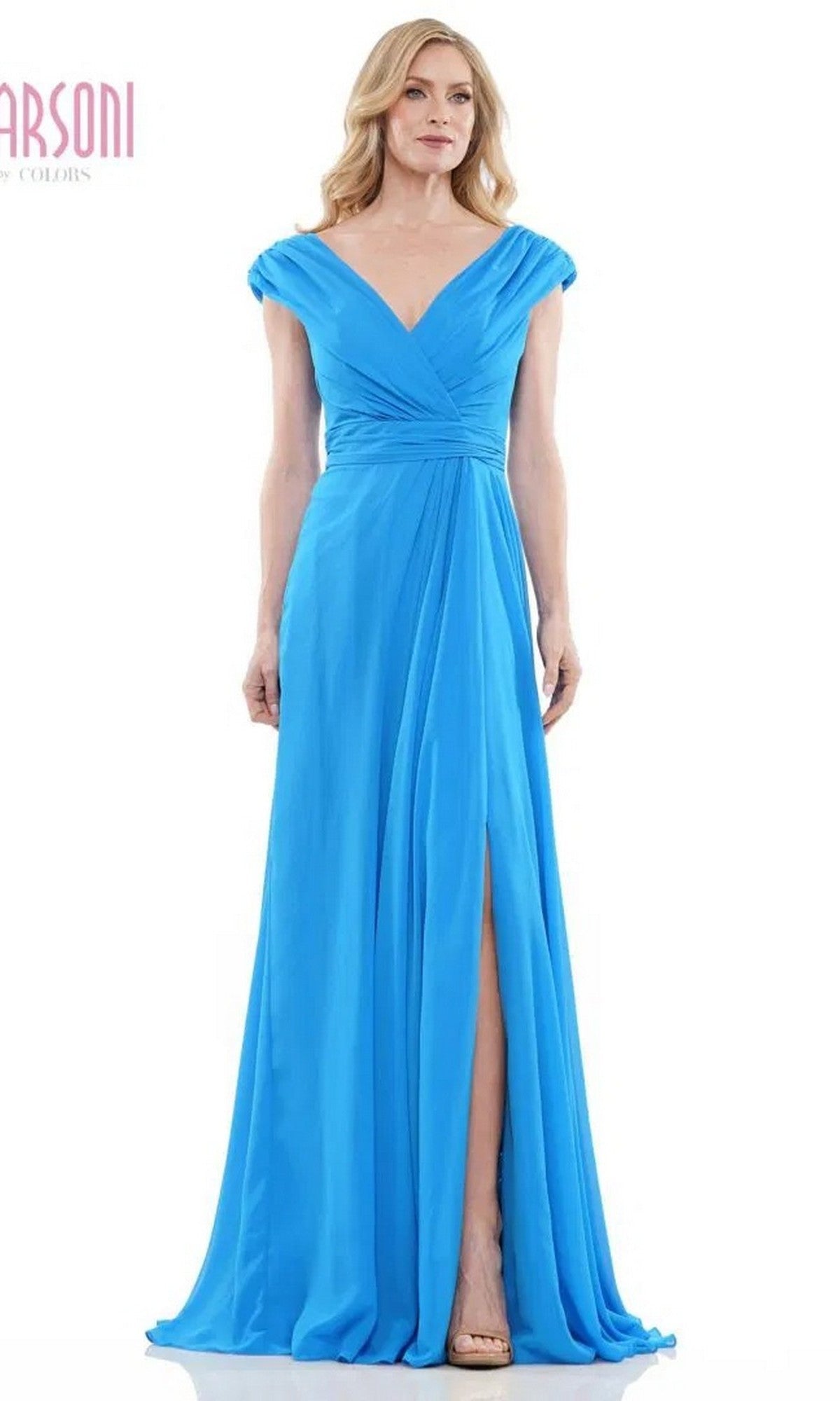 A woman stands facing forward in the Marsoni M251, a floor-length bright blue chiffon formal dress with cap sleeves, v-neckline, ruched waist, and high front slit.